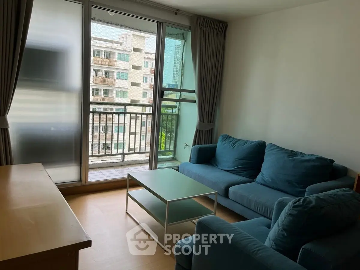 Cozy living room with blue sofas and balcony view in modern apartment