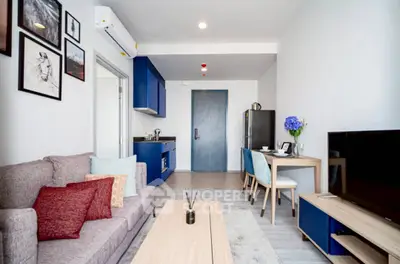 Modern living room with stylish decor and compact kitchen area, perfect for urban living.