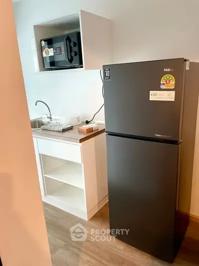 Modern kitchen with sleek fridge and microwave in compact layout