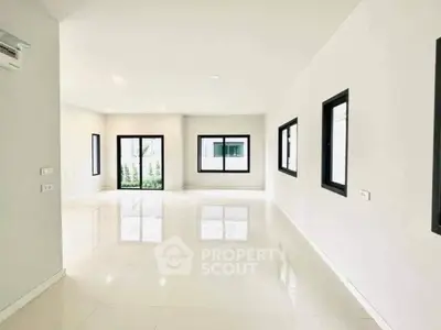 Spacious modern living room with large windows and glossy white floors