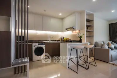 Modern open-layout kitchen with sleek design and integrated appliances in a stylish apartment.