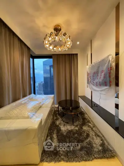 Luxurious modern living room with city view, elegant chandelier, and plush furnishings in high-rise apartment.