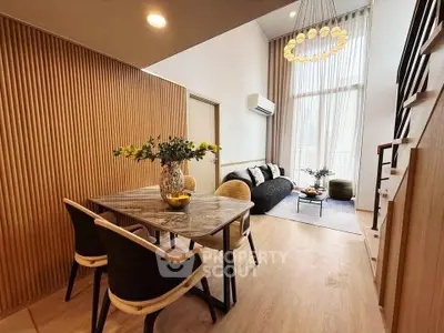 Modern living room with high ceilings, elegant lighting, and stylish furniture in a contemporary apartment.