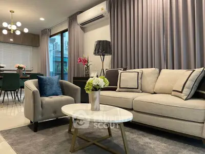 Elegant living room with modern decor, featuring plush seating and stylish lighting.