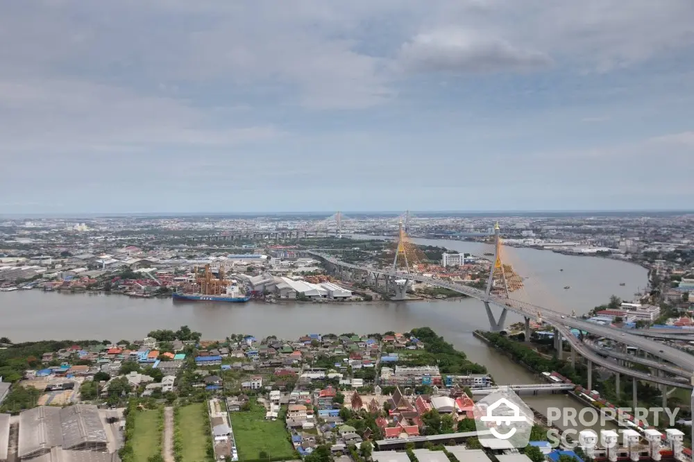 Stunning aerial view of cityscape with iconic bridge and river, showcasing urban development and connectivity.