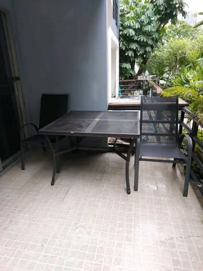Charming balcony with outdoor seating and lush greenery view.