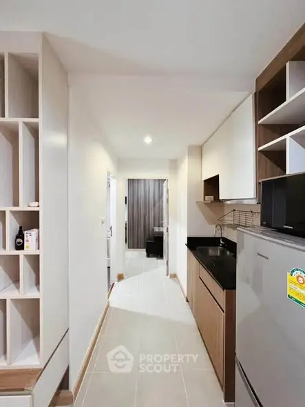 Modern kitchen with sleek cabinetry and built-in appliances in a compact apartment layout.