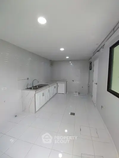 Spacious white kitchen with sleek modern design and ample counter space