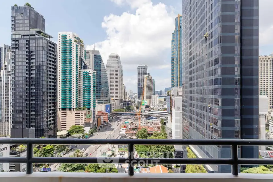 Stunning cityscape view from a high-rise balcony showcasing modern skyscrapers and vibrant urban life.