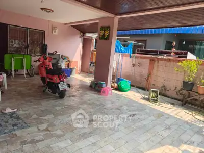 Spacious covered patio with scooter and laundry area in suburban home
