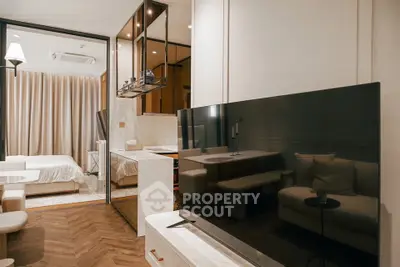 Modern studio apartment with open layout, featuring sleek kitchen and cozy living area.