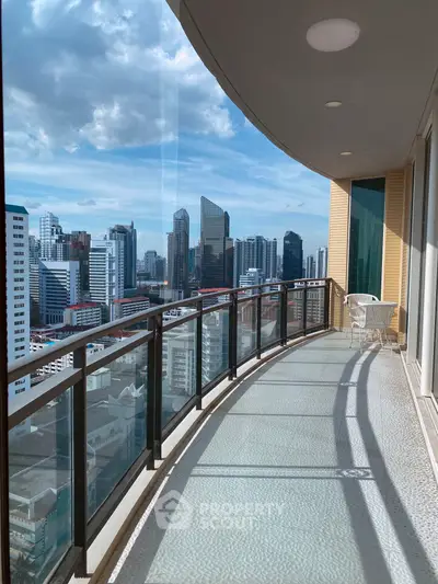 Stunning city view from a spacious high-rise balcony with modern glass railing.