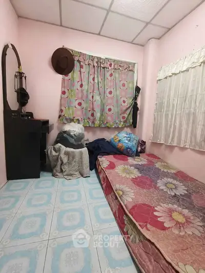 Cozy bedroom with floral bedding and colorful curtains, ideal for a personal retreat.