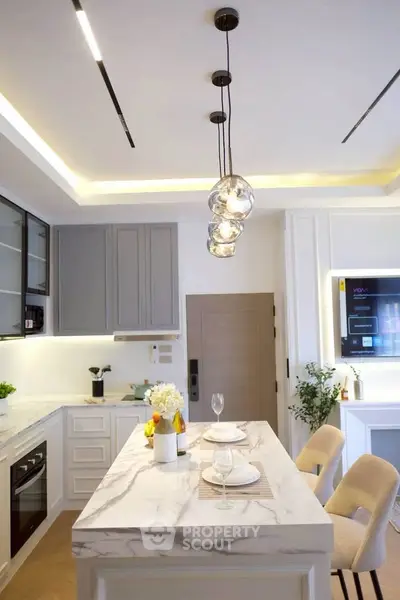 Modern kitchen with marble island and stylish lighting