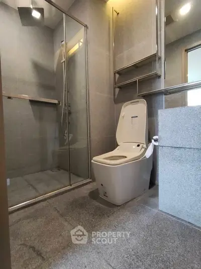 Modern bathroom with sleek shower and contemporary toilet design.