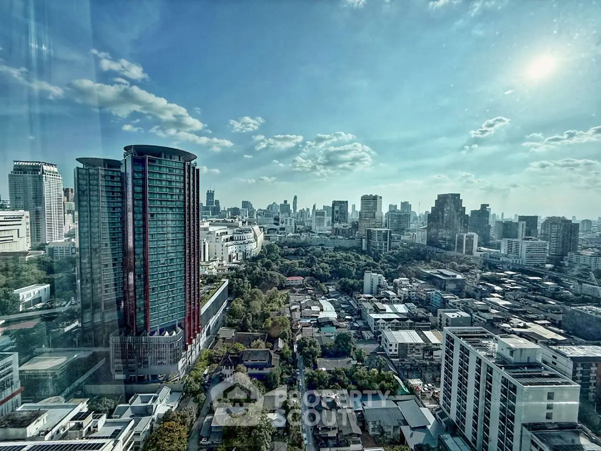 Stunning cityscape view from high-rise building with clear blue sky and urban skyline.