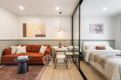 Modern studio apartment with stylish living area and cozy bedroom separated by glass partition.