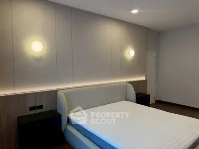 Modern bedroom with sleek design and ambient lighting, featuring a stylish bed and minimalist decor.
