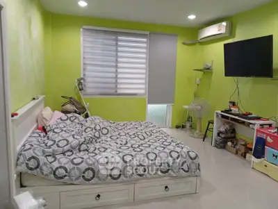 Cozy bedroom with modern decor, featuring a comfortable bed, wall-mounted TV, and air conditioning.