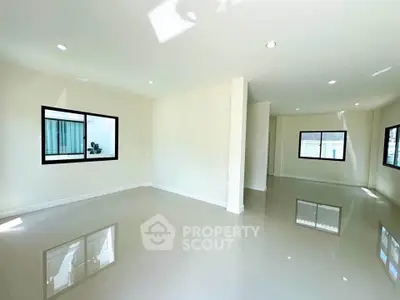 Spacious empty room with glossy tiled floors and large windows for natural light.