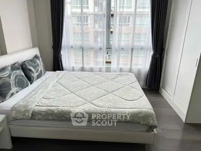 Modern bedroom with large window and stylish decor in urban apartment