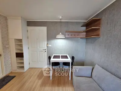 Modern living room with stylish furniture and wooden flooring, featuring a cozy sofa and dining area.