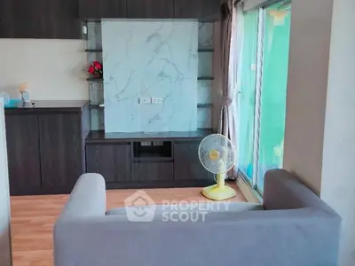 Modern living room with sleek dark wood cabinetry and large window for natural light.