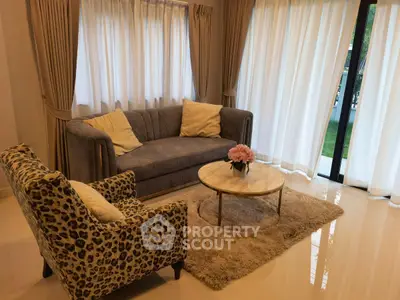 Elegant living room with plush sofa, stylish armchair, and chic coffee table in a bright, airy space.