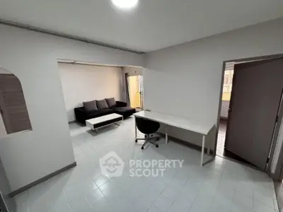 Spacious living room with modern furniture and study area, ideal for urban living.