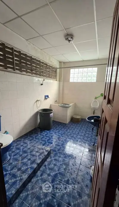 Spacious bathroom with blue tiled floor and modern fixtures, ideal for comfortable living.