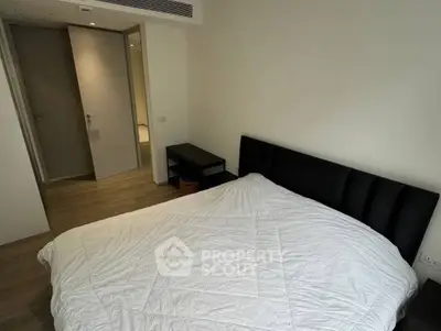 Modern bedroom with minimalist design and cozy ambiance, featuring a comfortable bed and sleek furniture.