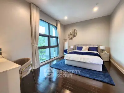 Spacious modern bedroom with elegant decor and large window view