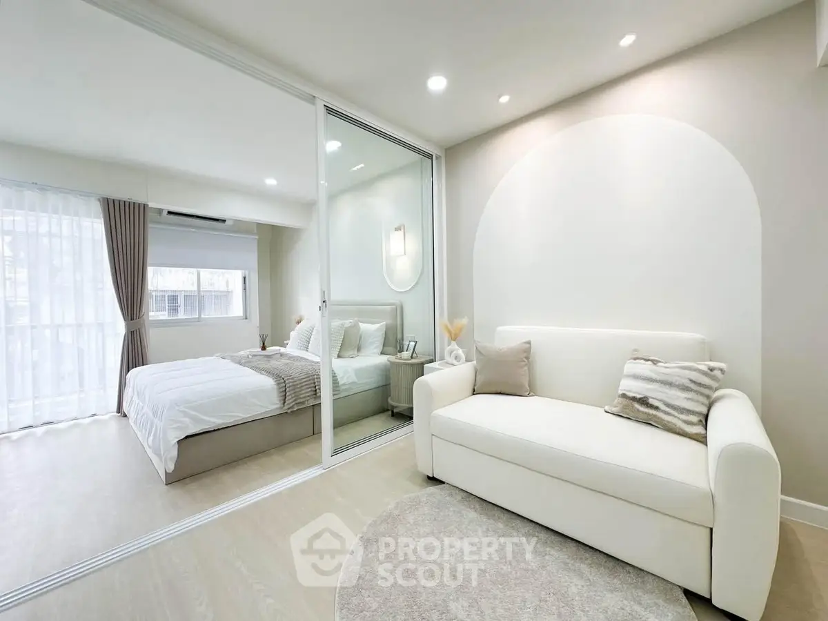 Modern bedroom with glass partition and cozy living area in elegant apartment