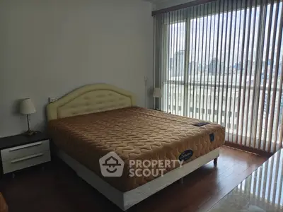 Spacious bedroom with large window offering city views and ample natural light.