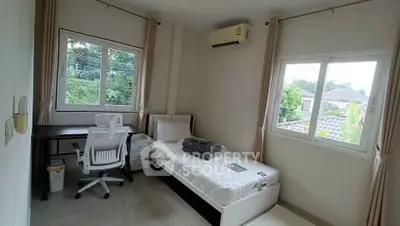 Cozy bedroom with single bed, study desk, and large windows offering lush garden views.