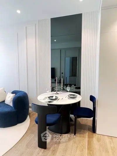 Modern living room with stylish dining area and elegant blue seating
