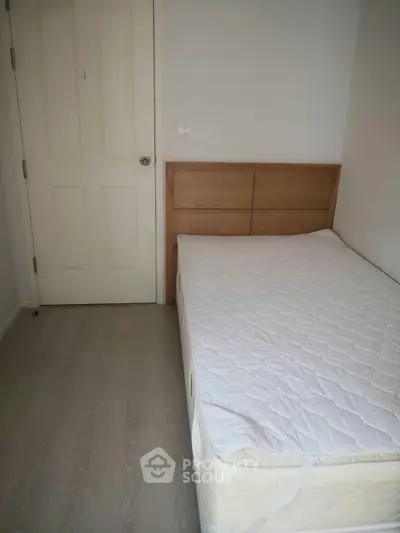Cozy bedroom with wooden headboard and minimalist design, perfect for a peaceful retreat.