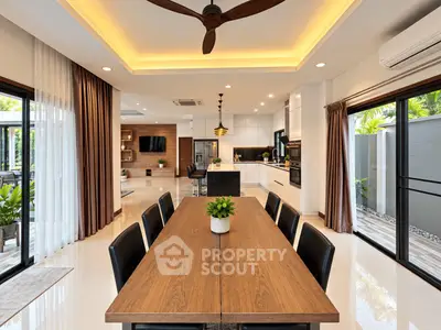 Luxurious open-plan living and dining area with modern kitchen and outdoor access, perfect for entertaining.
