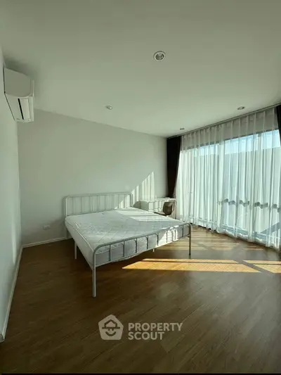 Spacious bedroom with natural light and minimalist decor