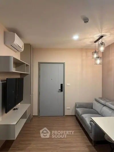 Modern living room with sleek furniture and ambient lighting, featuring a wall-mounted TV and stylish decor.