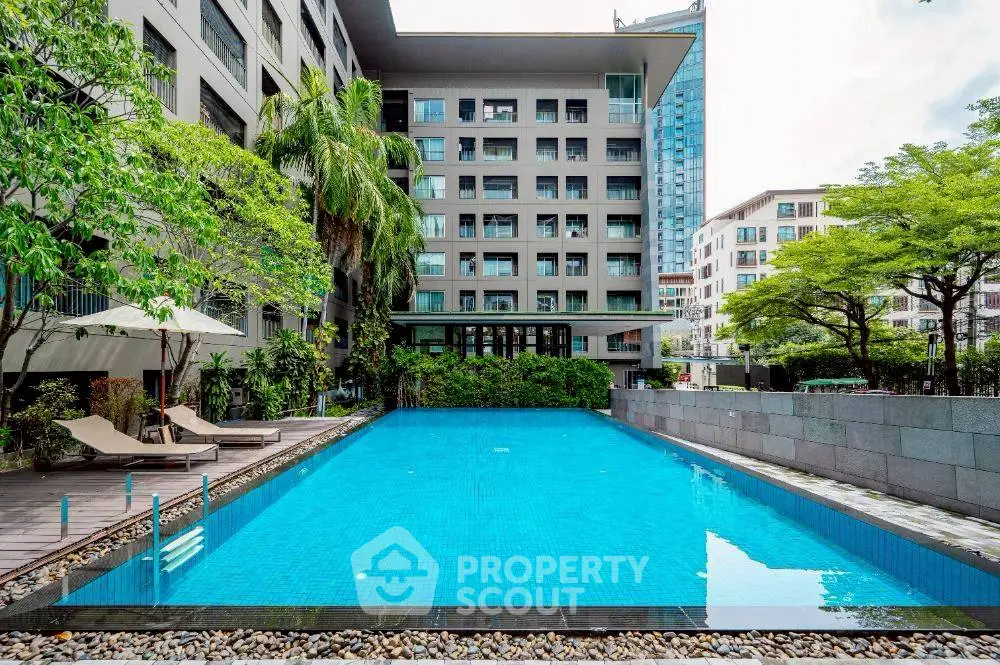 Luxurious apartment complex with a stunning outdoor pool and lush greenery.