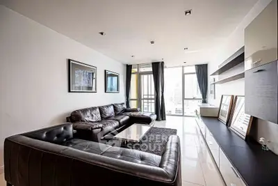 Modern living room with sleek leather sofas and city view balcony