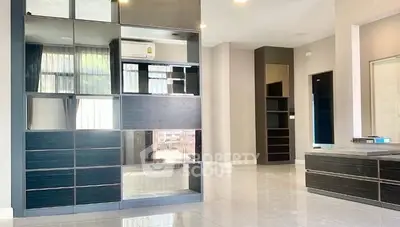 Spacious modern living room with sleek built-in storage and large windows.