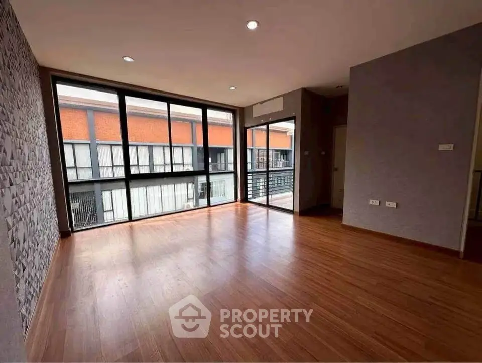 Spacious modern living room with large windows and wooden flooring