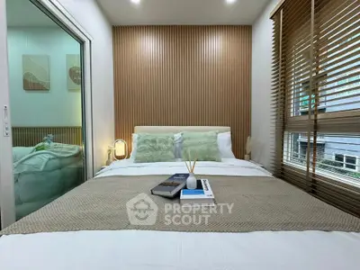 Cozy bedroom with modern decor, featuring a comfortable bed, stylish wooden paneling, and large windows for natural light.