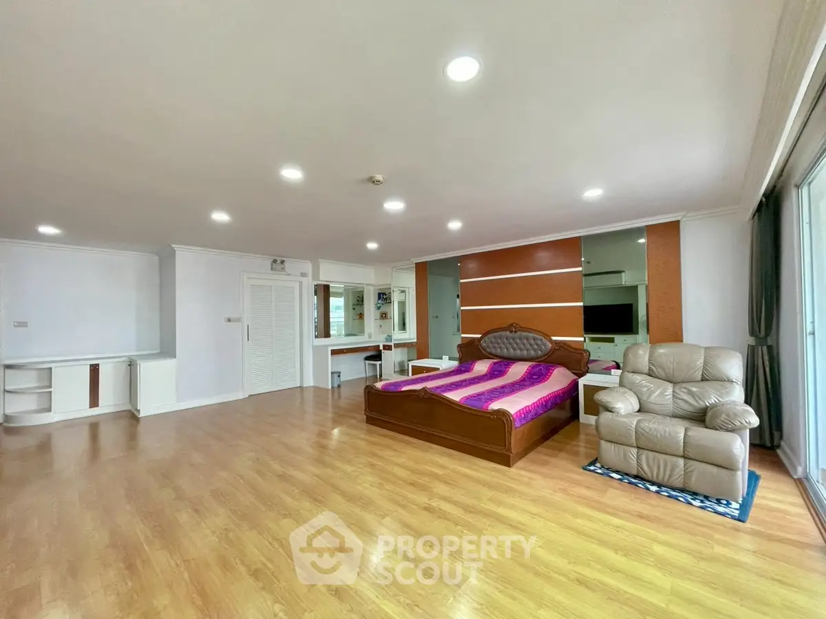 Spacious bedroom with modern decor and wooden flooring in a luxury apartment