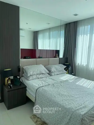 Luxurious bedroom with modern decor and large windows offering ample natural light.