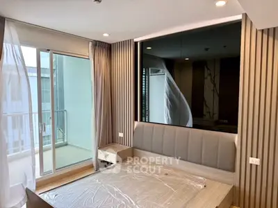 Modern bedroom with large window and balcony access, featuring stylish wooden paneling and neutral decor.