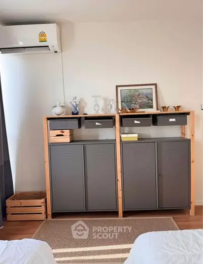 Cozy bedroom with stylish storage cabinets and air conditioning, perfect for modern living.