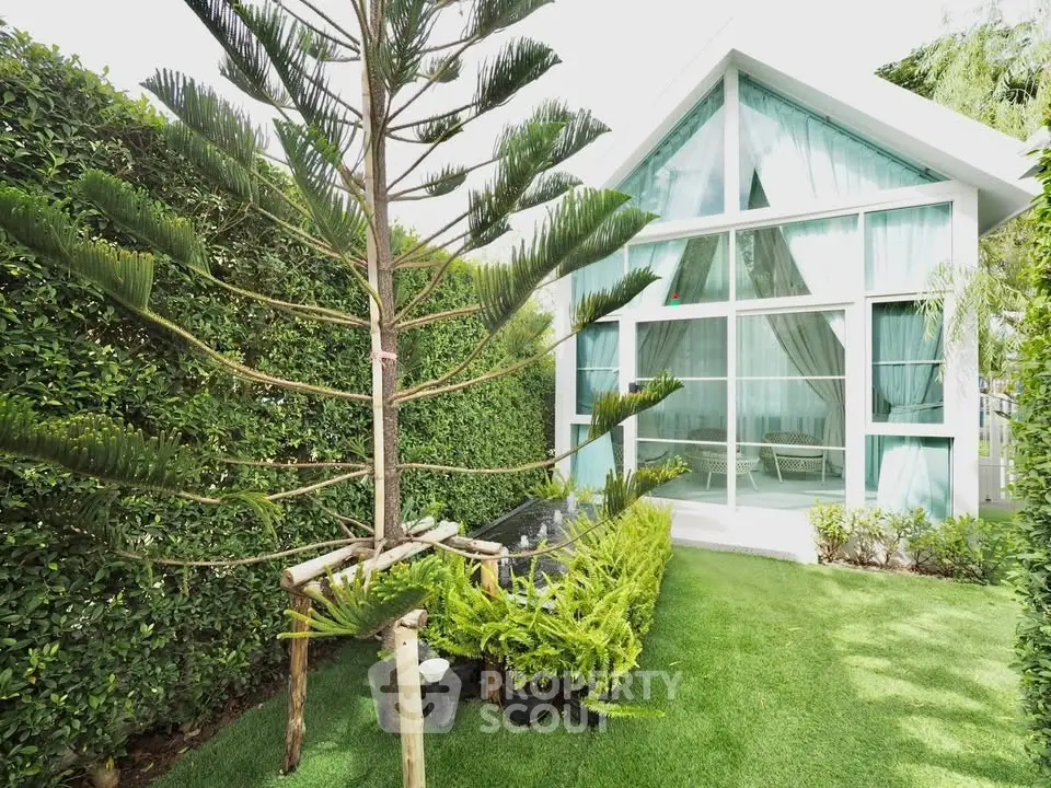 Charming modern house with lush garden and large glass windows, perfect for nature lovers seeking tranquility.